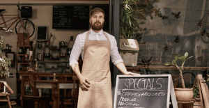 man standing next to chalk board sign